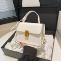 Bolso cuadrado blanco minimalista con broche dorado en una caja de regalo negra - Blanco