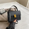 Bolso cuadrado de cuero negro con cierre en S dorado y correa de hombro - Negro