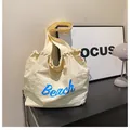 Minimalistische cremefarbene Canvas-Tasche mit blauem Beach-Schriftzug für Damen - Gebrochenes Weiß