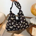 Bolso tote de lona negra con patrones de mariposas blancas y asa de hombro integrada - Estilo Estampado de Lazo Azul / Lazo Negro
