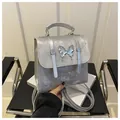 Metallic silver mini backpack featuring a stylish metal butterfly ornament and adjustable straps - Silver