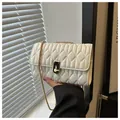 Elegant cream quilted chain crossbody bag with golden twist lock and textured finish - White