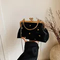 Schwarze Muscheltasche mit Herznieten und goldenem Rahmenverschluss mit Kettenriemen - Schwarz