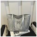 Dettaglio della borsa tote argento con texture metallica stropicciata e farfalla - Argento