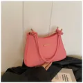 Pink and white striped woven saddle bag featuring knot shoulder strap and gold hardware - Pink