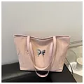 Minimalist light pink tote bag with textured finish and silver butterfly accent - Pink