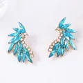 Macro detail of gold-plated wing earrings with marquise blue and white zircon stones - Blue