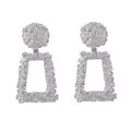 Close-up of silver geometric alloy drop earrings with unique embossed flower textures - Silver