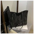Vista detallada del bolso tote grande negro con textura de cuero arrugado y costuras reforzadas - Negro