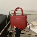 Minimalist red square crossbody handbag with fashion gold lettering and dual top handles - Red