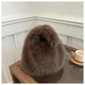 Dettaglio di una borsa in peluche marrone scuro con morbida ecopelliccia su un tavolo - Caffè