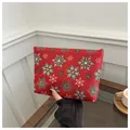 Detail of red Christmas makeup bag with festive snowflake patterns held in hand - Snowflake