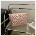 Detailed view of pink quilted fabric with heart pattern and golden zipper closure - Pink