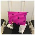 Detailed view of magenta quilted cosmetic bag with black bow embroidery and zipper - Rose Red