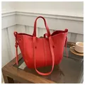 Detailopname van een rode getextureerde lederen draagtas met witte contraststiksels - Rood