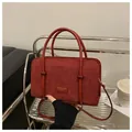 Detail of burgundy corduroy tote bag showing fine ribbed texture and stylish brand label - Red