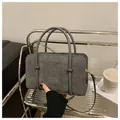 Detail of grey corduroy handbag featuring textured fabric and gold metal hardware - Gray