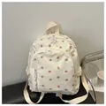 Detail of floral beige backpack with cherry print on a black leather stool - White
