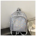 Close-up of light blue backpack with pink floral prints on water-repellent nylon fabric - Blue