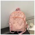 Close-up of pink floral backpack with high-capacity compartments and soft nylon texture - Pink