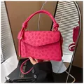 Fuchsia square crossbody bag with embossed clover pattern and knotted handle detail - Pink