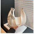 White leather half-moon underarm bag featuring a metallic silver bead bow charm - White