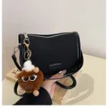 Schwarze Halbmond-Umhängetasche mit Fashion-Label und braunem Plüsch-Anhänger - Mit Anhänger / Schwarz