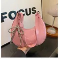 Pink crescent hobo bag in shiny patent leather featuring a beaded bow charm - Pink