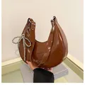 Dark brown crescent underarm bag in glossy patent leather with a silver bow charm - Dark Brown