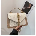 Close-up of woven off-white texture with khaki leather trim and gold buckle on a handbag - White