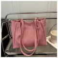 Detail view of the woven pink tote bag with metal ring connectors and long shoulder strap - Pink