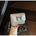 Mini metallic silver chain bag for women with decorative bow clasp and pearl finish - Silver