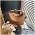 Brown woven crossbody bag with semi-circular silhouette and golden metal clasp - Dark Brown