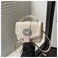 Detail of elegant cream faux leather handbag featuring a luxury rhinestone square buckle - White