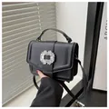 Detail of black lychee grain leather bag with a crystal-encrusted square buckle - Black