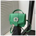 Macro shot of green pebble leather texture and luxury sparkling crystal buckle on handbag - Green
