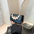 Black faux-crocodile leather crossbody bag with pearl handle and golden twist lock - Black