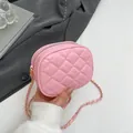 Rosafarbene gesteppte Mini-Tasche mit Goldkette, elegant in der Hand präsentiert - Rosa