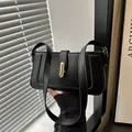 Elegante bolso de hombro de cuero sintético negro con herrajes dorados y correa ancha - Negro