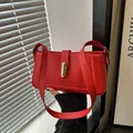 Elegante bolso de hombro en cuero mate rojo con cierre giratorio dorado y correa ancha - Rojo