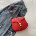 Vintage red leather saddle bag with gold buckle on denim jacket for women - Red