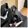 Chic black pleated hobo bucket bag with knotted handle detail in glossy faux leather - Black