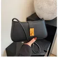 Minimalist black leather underarm bag with elegant gold metallic buckle detail - Black