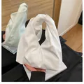 Minimalist white pleated bucket bag with a stylish knotted handle and soft leather texture - White