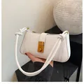 White leather underarm bag with gold rectangular clasp and knotted strap detail - White