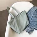 Minimalistische mintgrüne Nylon-Tragetasche mit Logo und schmalen Schultergurten - Grün