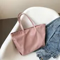 Sac fourre-tout en nylon rose à grande capacité avec logo, présenté sur une chaise - Rose