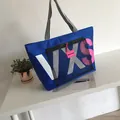 Large blue tote bag with front mesh pocket and striped handles for beach travel - Blue