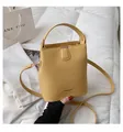 Ingwergelbe Eimertasche aus Kunstleder mit breitem Griff und Umhängeriemen - Gelb
