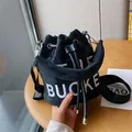 Borsa a secchiello in peluche nera con ricamo THE BUCKET bianco e chiusura a coulisse - Nero